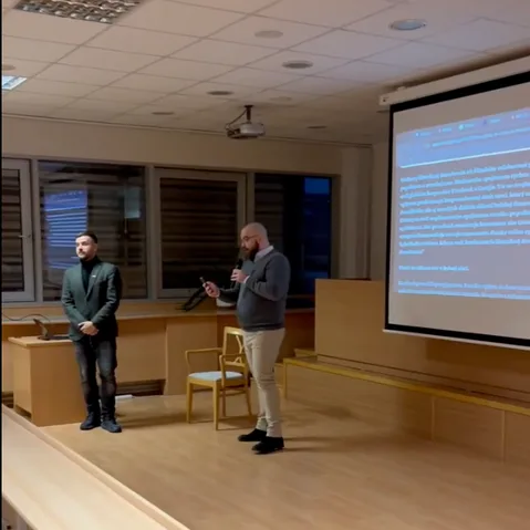 Two workshop presenters with projected slide in the back.